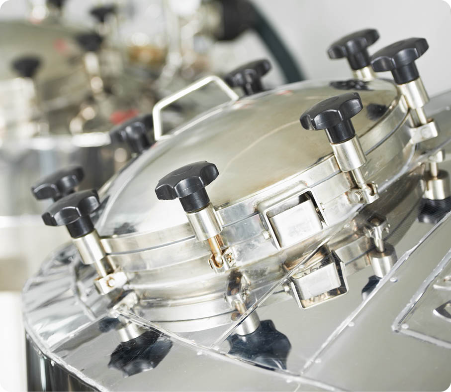 A stainless steel pressure cooker lid in an industrial setting 