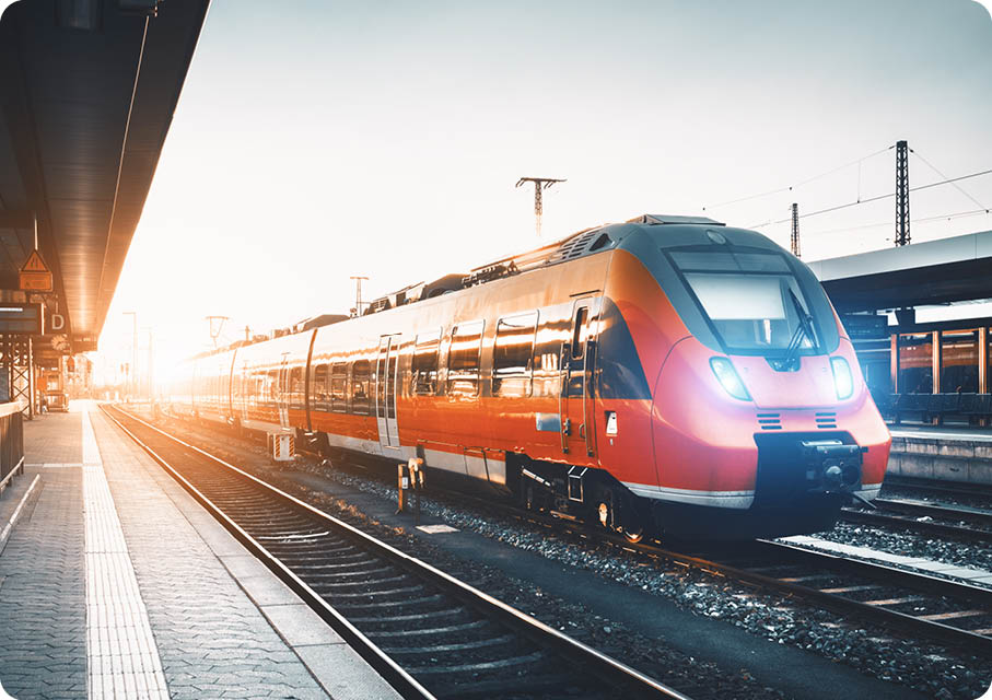 Modern high speed red commuter train at the railway station at sunset  Turning on train headlights  Railroad with vintage toning  Train at railway platform  Industrial landscape  Railway tourism 