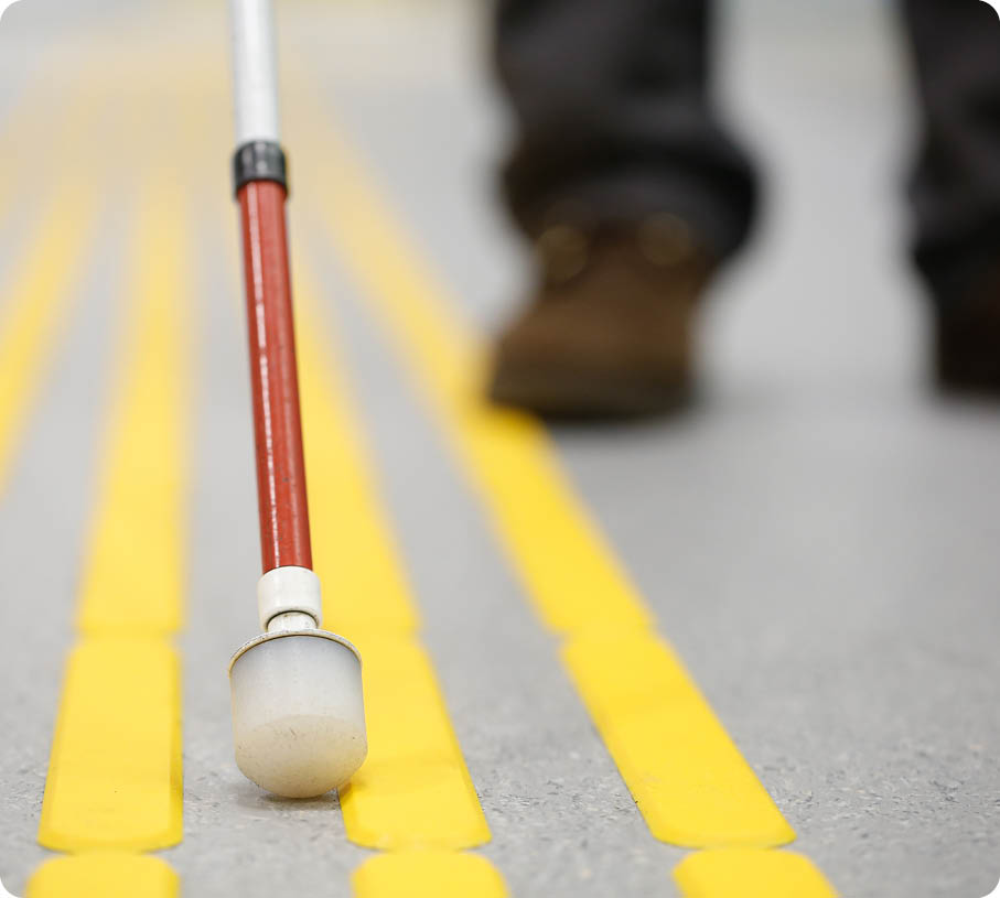 Blind pedestrian walking and detecting markings on tactile paving with textured ground surface indicators for blind and visually impaired  Blindness aid, visual impairment, independent life concept 
