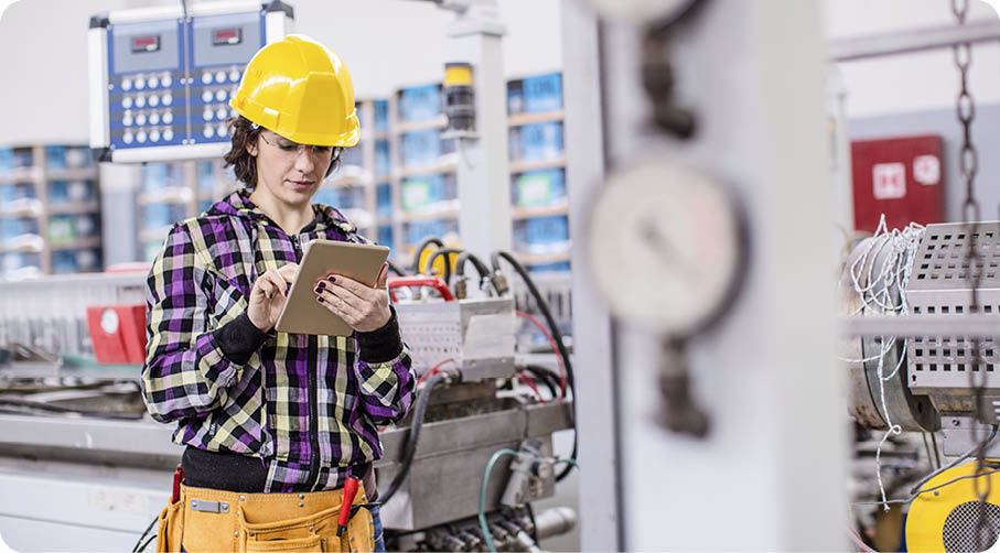 Professional Confident Worker Wearing Hard Hat Checks Stock and Inventory with Digital Tablet Computer in a factory 