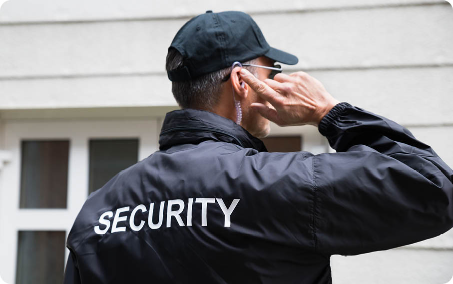Male security guard in uniform on urban background, seen from behind 